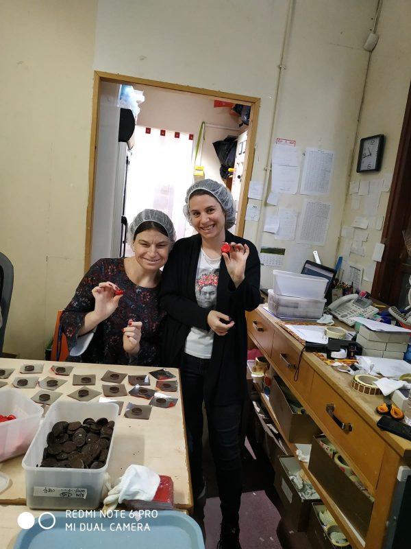 2 נשים עם חיוך גדול מציגות למצלמה מוצרים משוקולד מעשה ידיהן קלאבהאוס טבריה